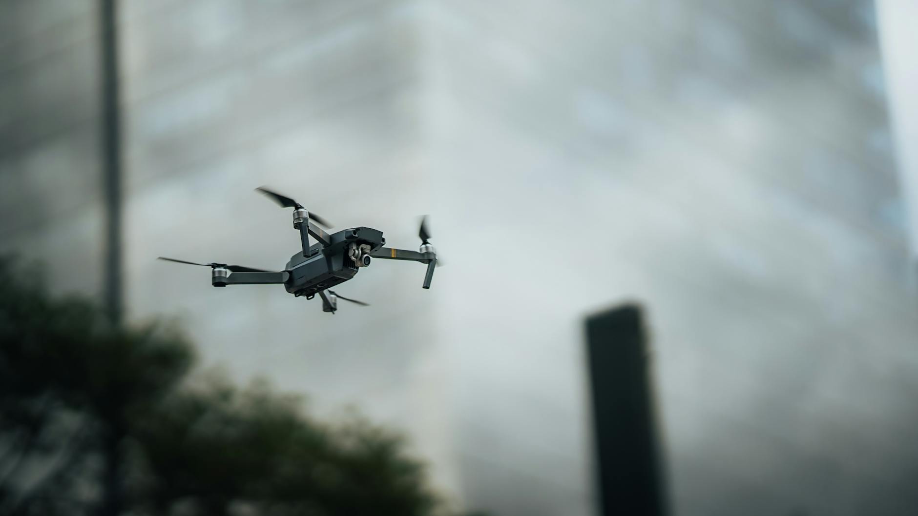 Dron unoszący się między wysokimi budynkami w centrum miasta